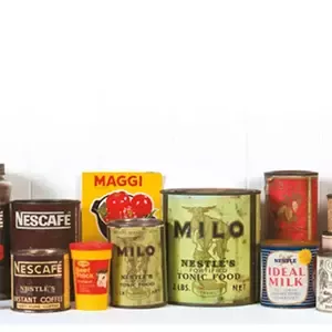Historic Nestlé product packaging collection featuring Nescafé, Milo, Maggi and Ideal Milk tins